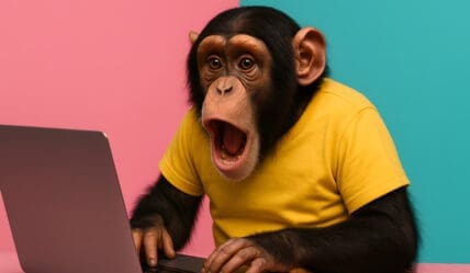 Is your website really working for you? Picture of a monkey in a yellow t-shirt using a laptop
